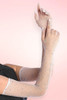 White rhinestone fishnet gloves, long opera length with scattered blue and clear crystal embellishments, arms crossed against pink background.