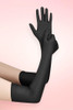 Long black spandex opera gloves in elbow length worn on both arms, one arm raised with open palm, against a pink background.