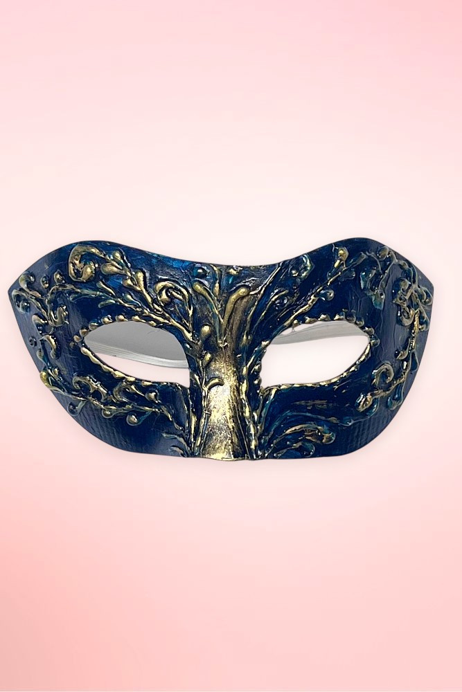 Handmade navy and gold Venetian masquerade mask flat lay on pink background.