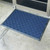 Blue Wellington carpet mat on cement floor outside of glass door