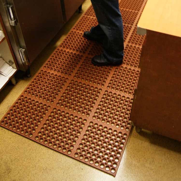  Person standing on Red Dura-Chef Anti-Fatigue Mats in commercial kitchen