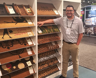 Cheerful Employee standing near display of Coir Mats