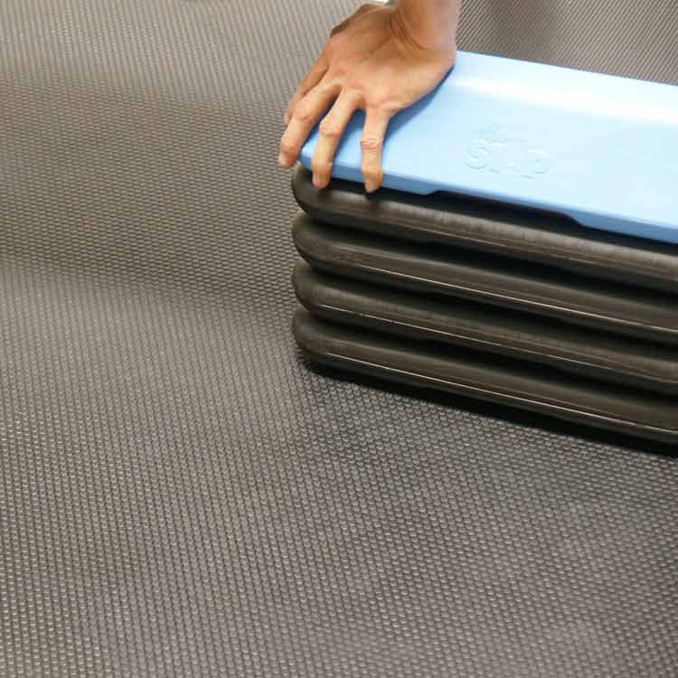 person resting their hand on top of equipment underneath black tuff flex in a room