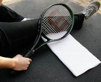 Person resting with a Tennis Racquet on Shark Tooth Mat