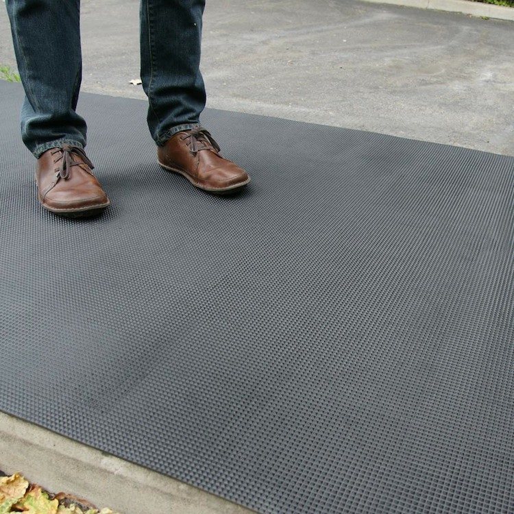 person with brown shoes standing on super grip rubber mat