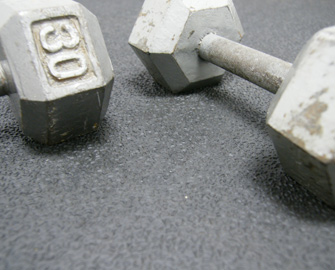 Two 30 lb dumbbells on a thick rubber workout mat