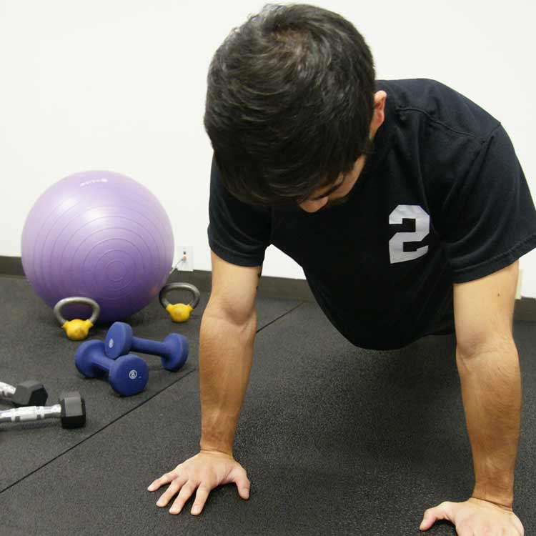 Person doing a push up on a shock absorbent rubber floor