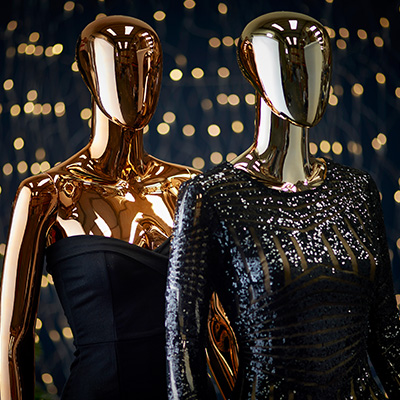 Golden mannequins wearing very formal clothes.