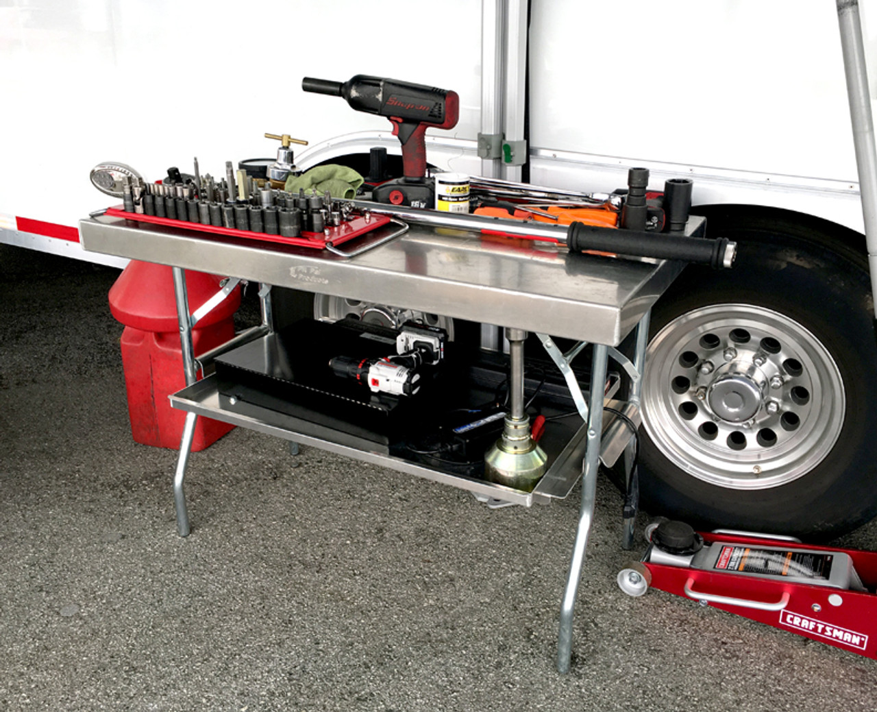 aluminum folding table with tools on top in front of trailer
