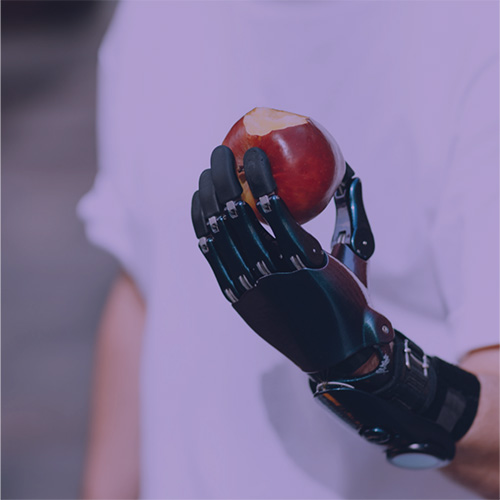 person with a prosthetic arm holding an apple