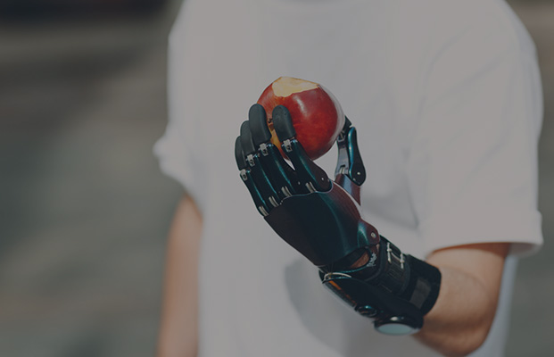 a man with a prosthetic arm holding an apple