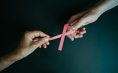 hands with pink ribbon