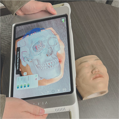 model head being scanned on an iPad with an augmented reality overlay on the screen
