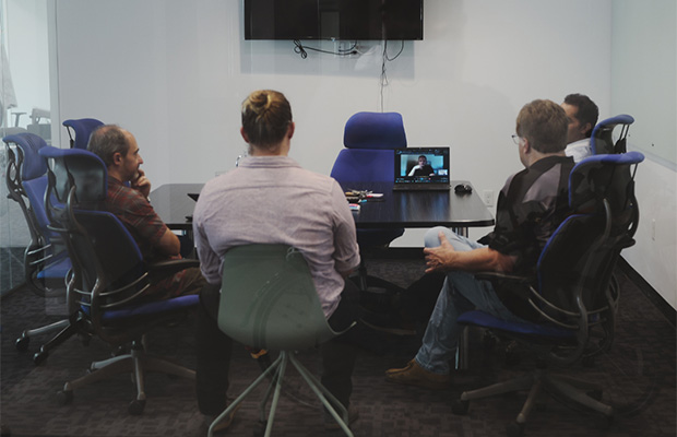 team around a table with computers
