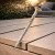 DeckingPro DS50 RAL 1019 Grey Beige colour matched composite decking screw shown on teak composite decking boards outdoor