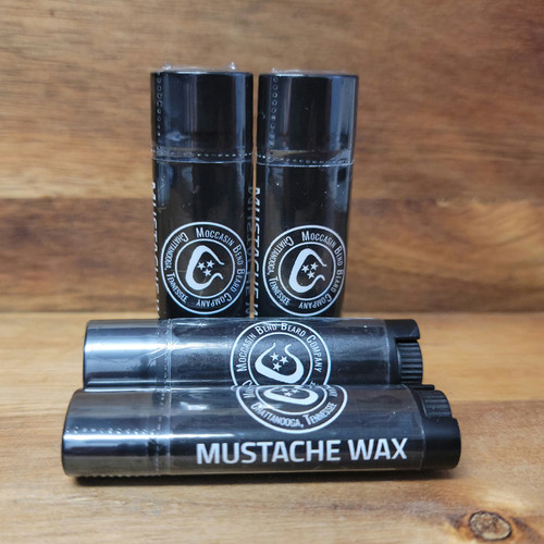 multiple, black, oval shaped lip balm type tubes of mustache wax.
