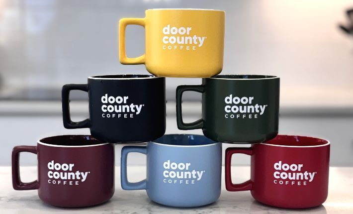 Two speckled door country coffee mugs on a countertop