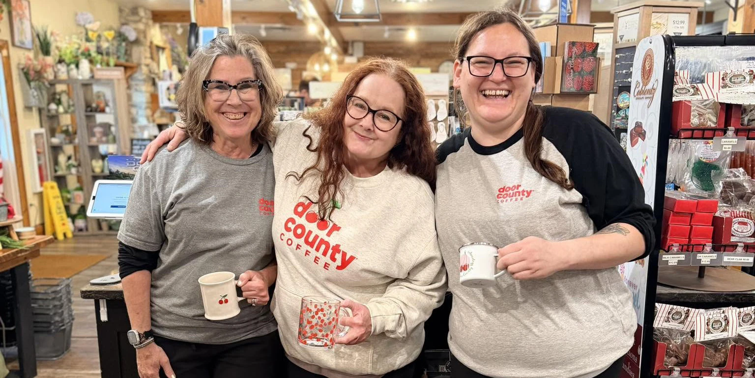 three female baristas smiling