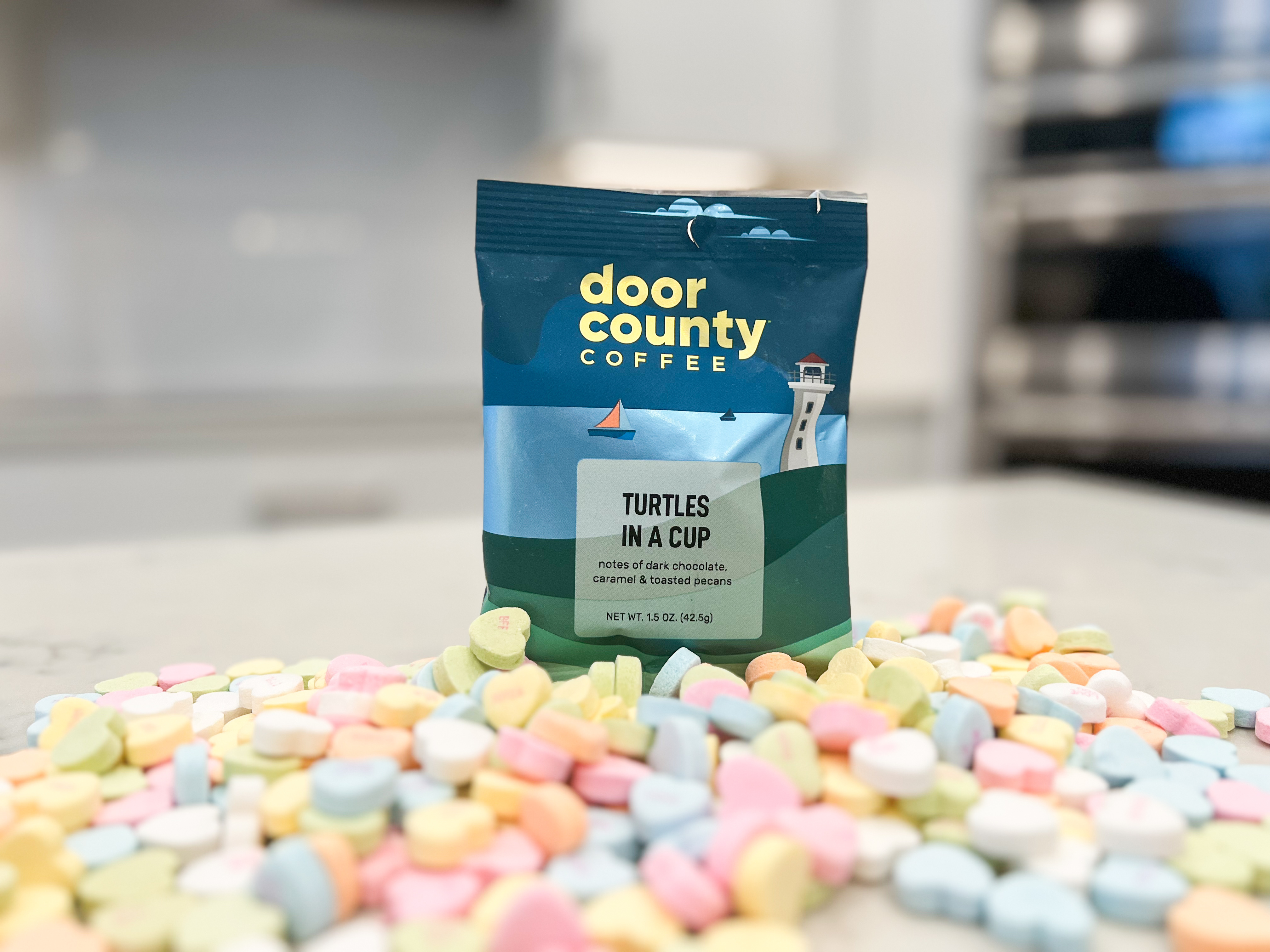 A bag of coffee with candy hearts by it