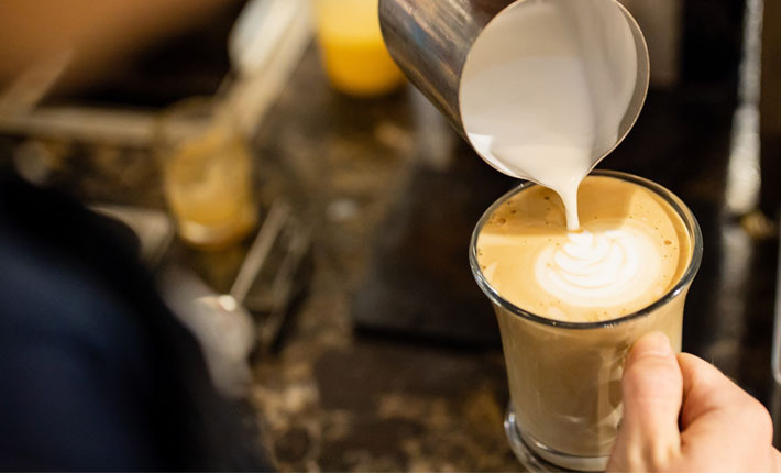 cream being poured artistically into a latte
