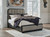 Rowanbeck - 7 Pc. - Dresser, Mirror, Chest, Queen Upholstered Panel Bed, 2 Nightstands - Gray / Black