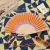 Hand fan orange and purple waves