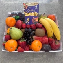 Sweet & Fresh Fruit Tray with seasonal fruit and 373 g box of favorite chocolates, wrapped in cellophane with ribbons