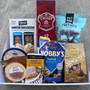 Gift hamper with pretzel, chocolates, nuts, dip, cheese, crackers and bottle of spirits.