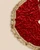 Close-up of handmade red velvet Christmas tree skirt with abundant crystal embellishments, luxurious gold tassels and rich velvet texture.