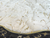 Close-up of plush ivory-white faux fur Christmas tree skirt with shimmering gold leaf detailing and elegant metallic gold piping.