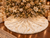 Luxury 55-inch white faux fur Christmas tree skirt by SADE New York, featuring metallic gold accents and elegant gold trim beneath a beautifully decorated Christmas tree.