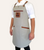 Close-up of leather name patch on custom canvas apron with pocket details