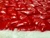 Detailed view of a red Christmas tree skirt featuring glossy raised quilting and a soft white faux fur border for elegant holiday decoration.