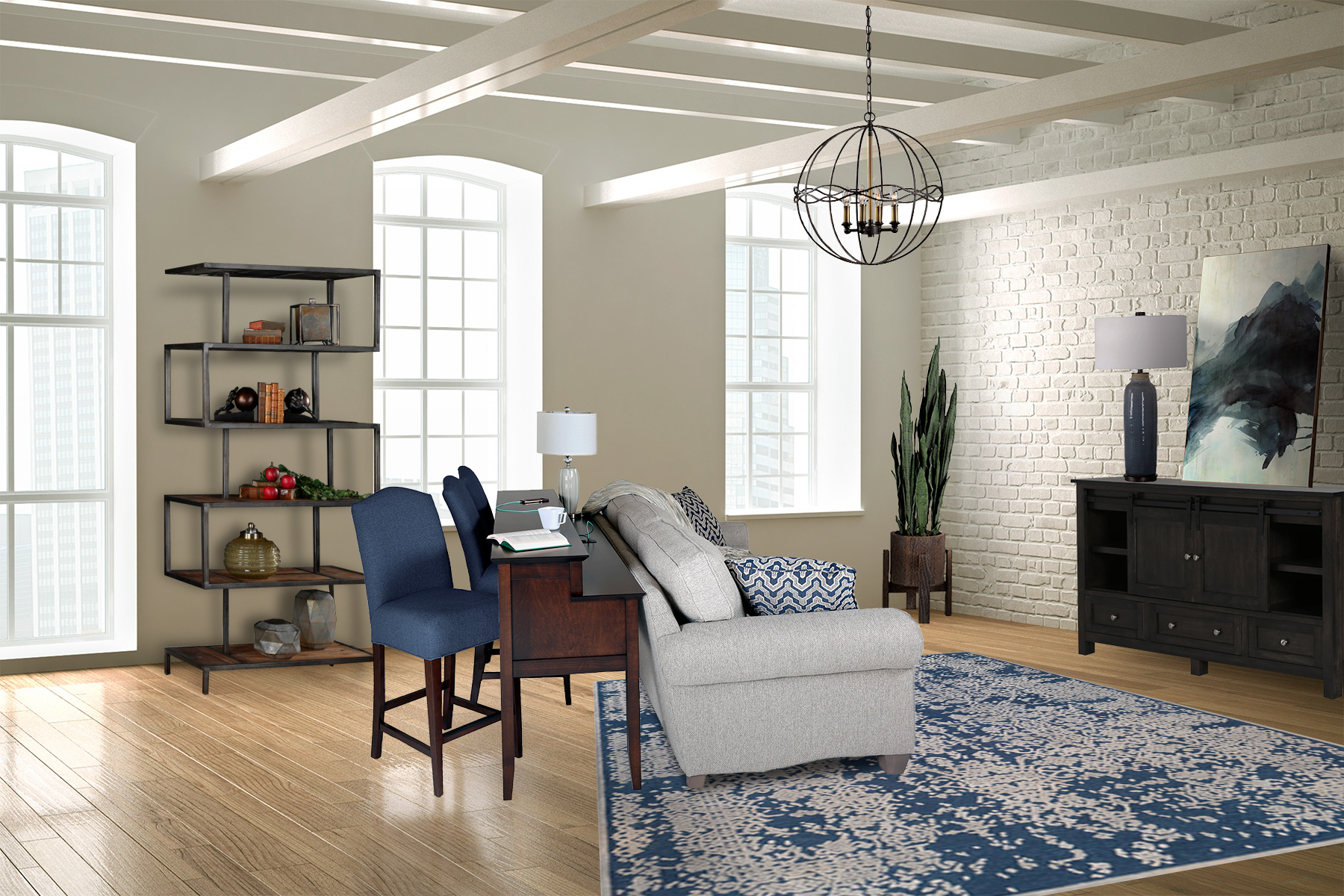 A grey sofa sits with a small desk behind it that has two blue chairs slid beneath in a white living room with exposed white beams and a white brick wall