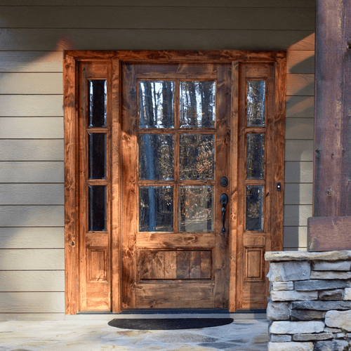 Knotty alder 6 Lite single front entry door with matching sidelights featuring clear bevel glass for rustic warmth, natural light, and handcrafted charm. Available at GrandEntryDoors.com.