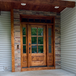 Rustic knotty alder 6 Lite front door with clear bevel glass sidelights and transom showcasing rich wood grain and handcrafted detail. Available at GrandEntryDoors.com.