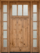 Warm knotty alder Craftsman 3 lite front door with clear bevel glass and matching sidelights creating a bright, inviting entryway.