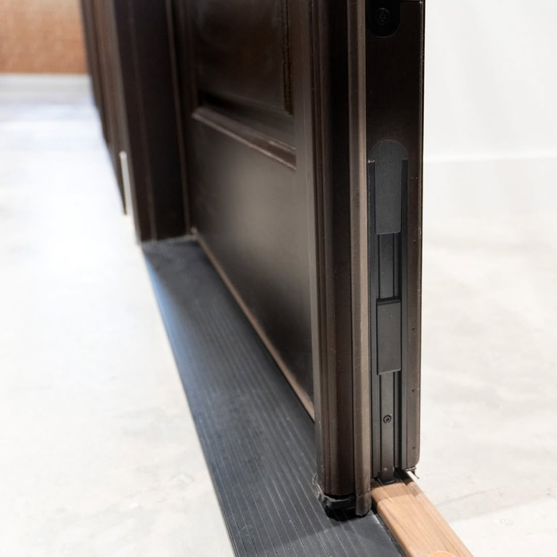 Close up of flush bolt hardware on a double entry door, integrated into the door edge.