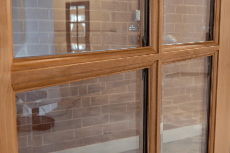 Close-up view of a knotty alder door showing the true divided lite (TDL) profile and clear bevel glass, highlighting precise craftsmanship, natural wood grain, and detailed joinery. Available at GrandEntryDoors.com.