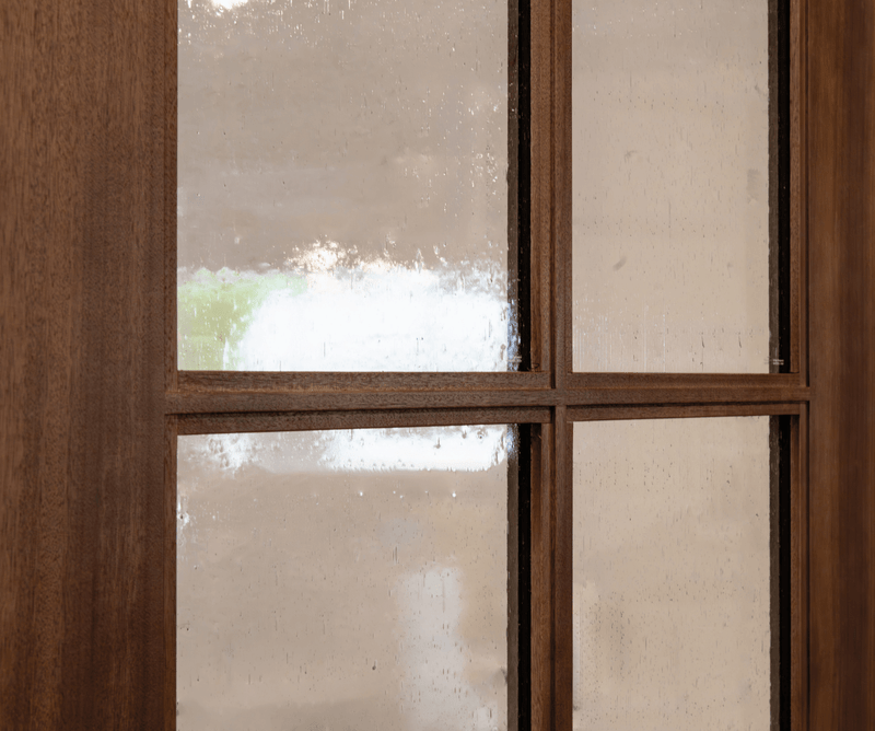 Close-up of step sticking True Divided Lite (TDL) profile on a wood door, showing detailed muntin joinery and beveled sticking around the insulated glass