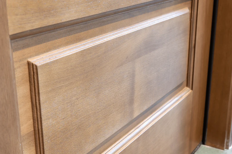 Close-up of mahogany door ovolo panel design highlighting elegant contours, smooth craftsmanship, and rich wood texture. Available at GrandEntryDoors.com.