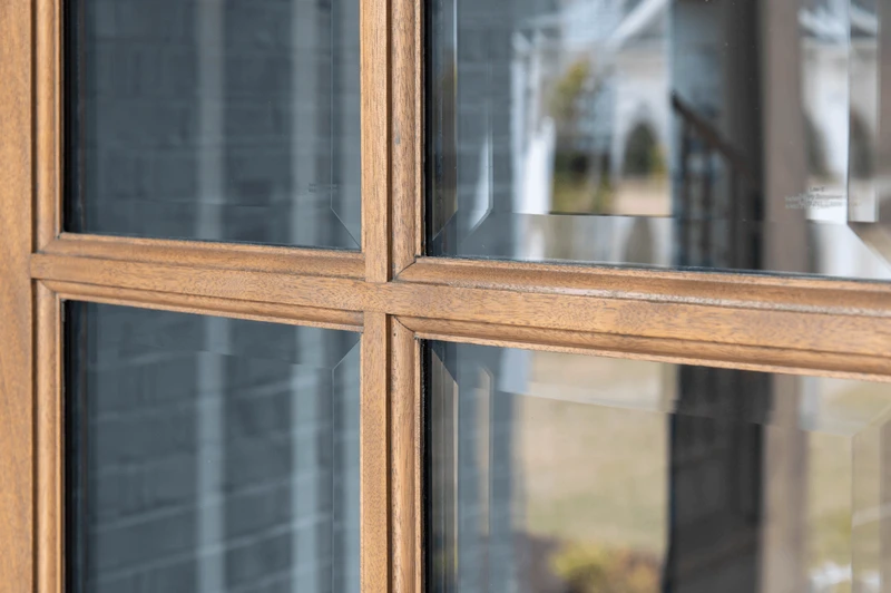 Close-up of mahogany true divided lite (TDL) profile showing precise muntin detailing, clear bevel glass, and smooth handcrafted finish. Available at GrandEntryDoors.com.