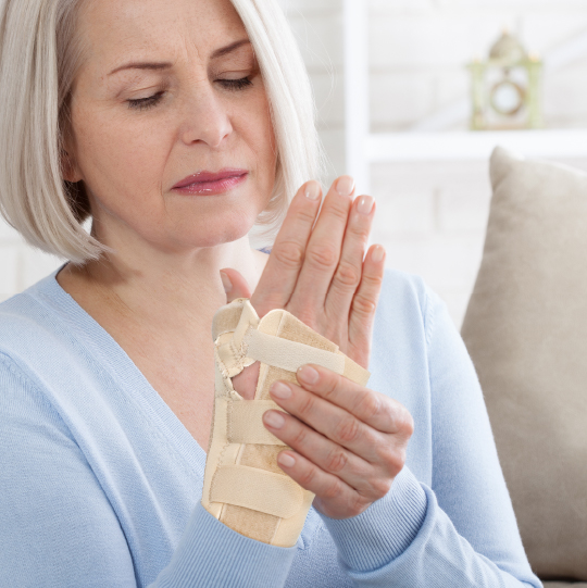 A woman wearing a wrist splint to immobilise her wrist and thumb