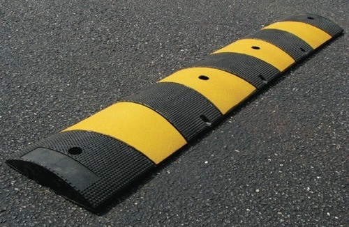Black and yellow speed bump installed on pavement