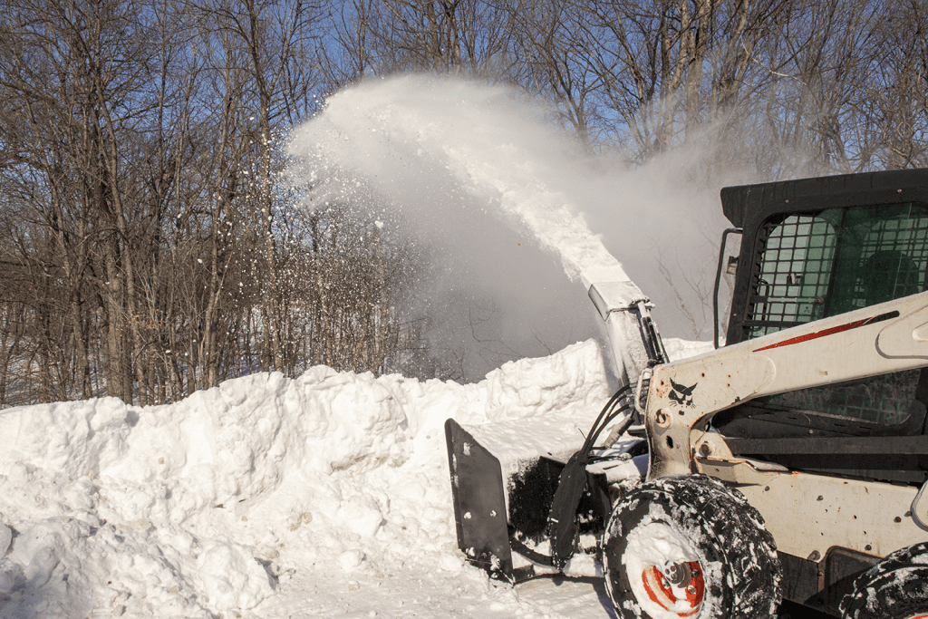 Skid steer snow blower throwing snow