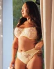 Model looking out he window while wearing a delightful Yellow and white bra and panty set with lemon embroidery.