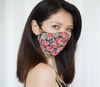 An Asian woman with mid-length hair wears a red floral face mask by Sainted Sisters