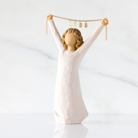 Front view: figure in cream dress holding gold chain above her head with year 2025 on it