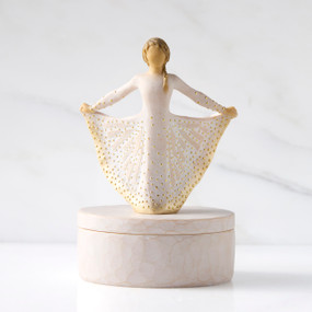 Front view: oval resin box, with 3-D figure in cream and gold carved dress atop lid