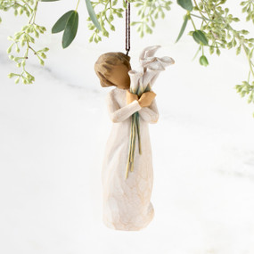 Front view of figure in cream dress with short hair holding tall bouquet of white calla lillies, ornament hook affixed to top of head